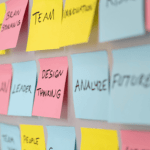 Een strategische planner omringd door een mozaïek van kleurrijke post-it notities, die de synergie tussen intuïtie en strategische bedrijfsplanning symboliseren.