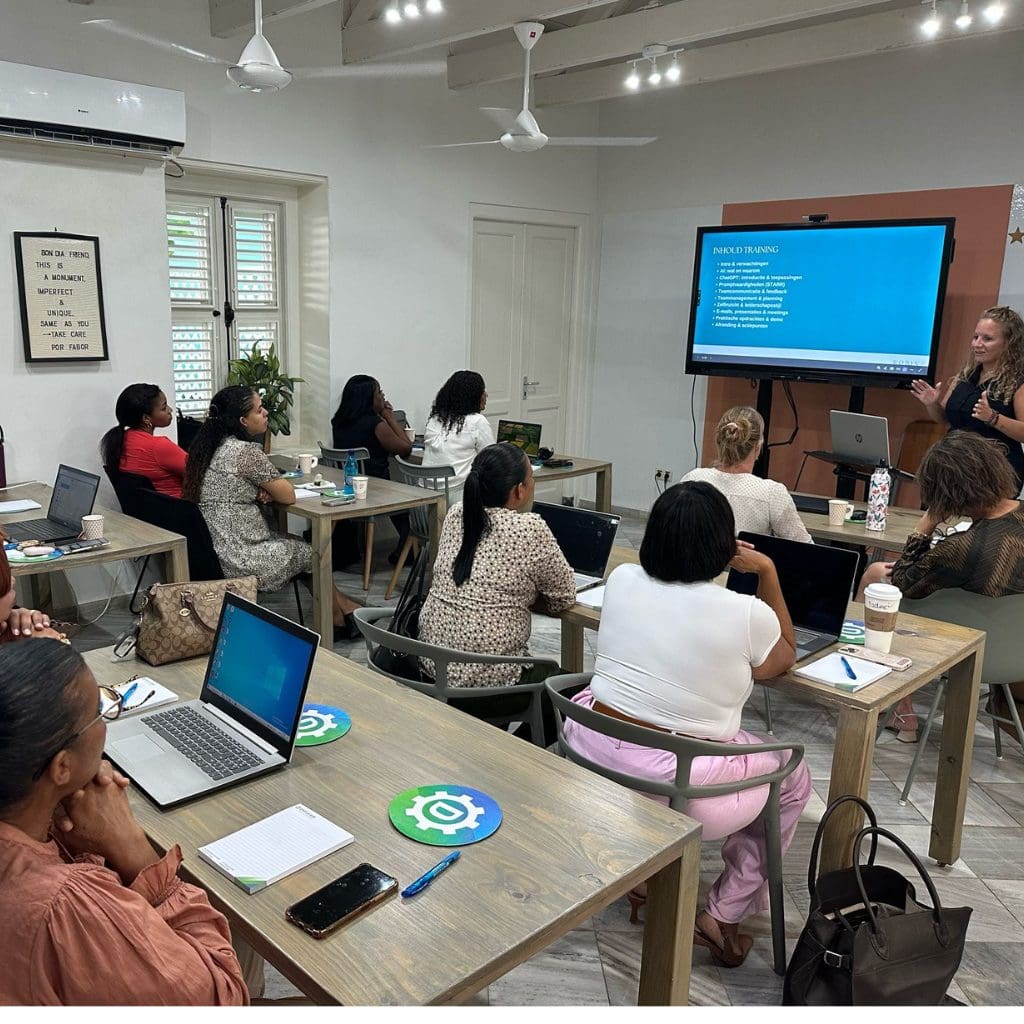 Robin Devid geeft ChatGPT-training aan managers op Curaçao – groep deelnemers met laptops tijdens interactieve sessie bij Kura Hulanda.